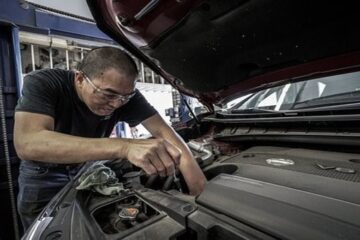 Un homme répare une voiture