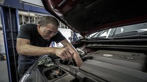 Un homme répare une voiture
