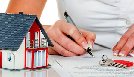 a woman signs a contract for a house with a real estate agent.