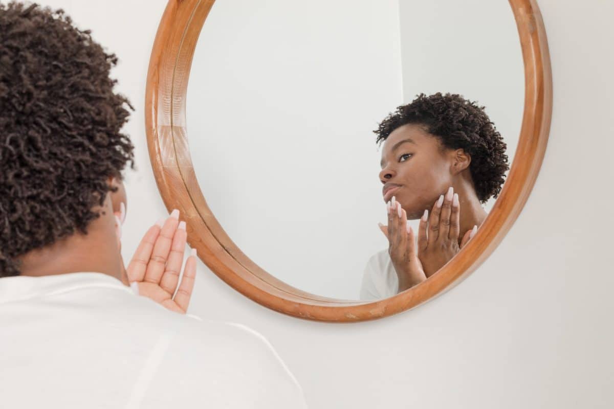 man wearing white shirt facing on wall mirror