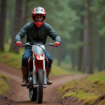 Jeune homme en motocross sur une moto 125cc en forêt
