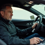 Homme en veste sombre dans une voiture sportive moderne