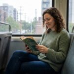 Femme lisant un livre dans un train pendant son trajet quotidien, profitant de son temps de transport pour se détendre