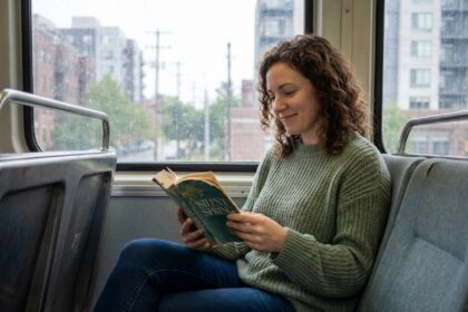 Femme lisant un livre dans un train pendant son trajet quotidien, profitant de son temps de transport pour se détendre